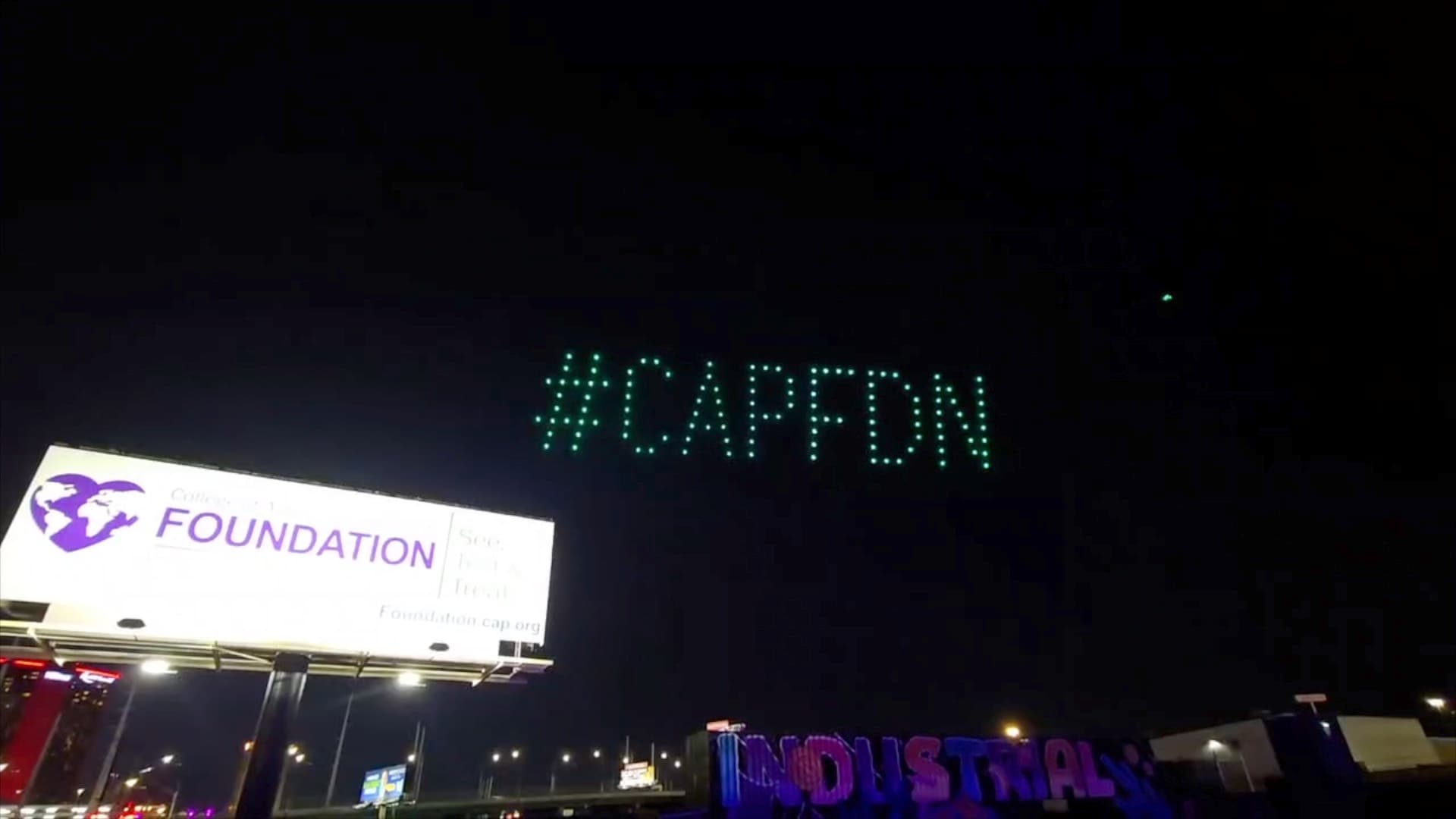 Drones spell a CAP Foundation hashtag above the INDUSTRIAL and a CAP Foundation billboard