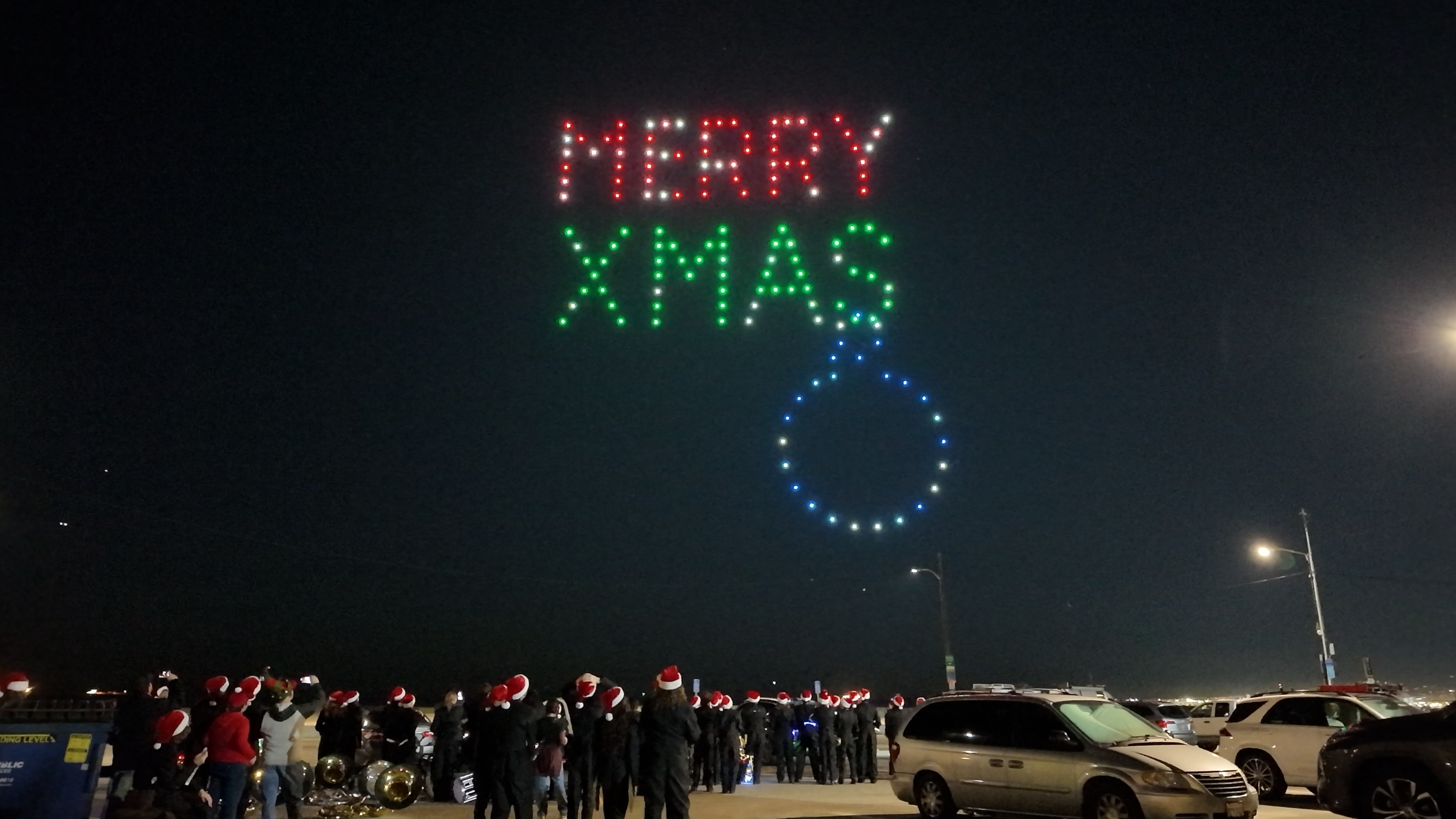 Merry Christmas lettering formed by drones in the night sky