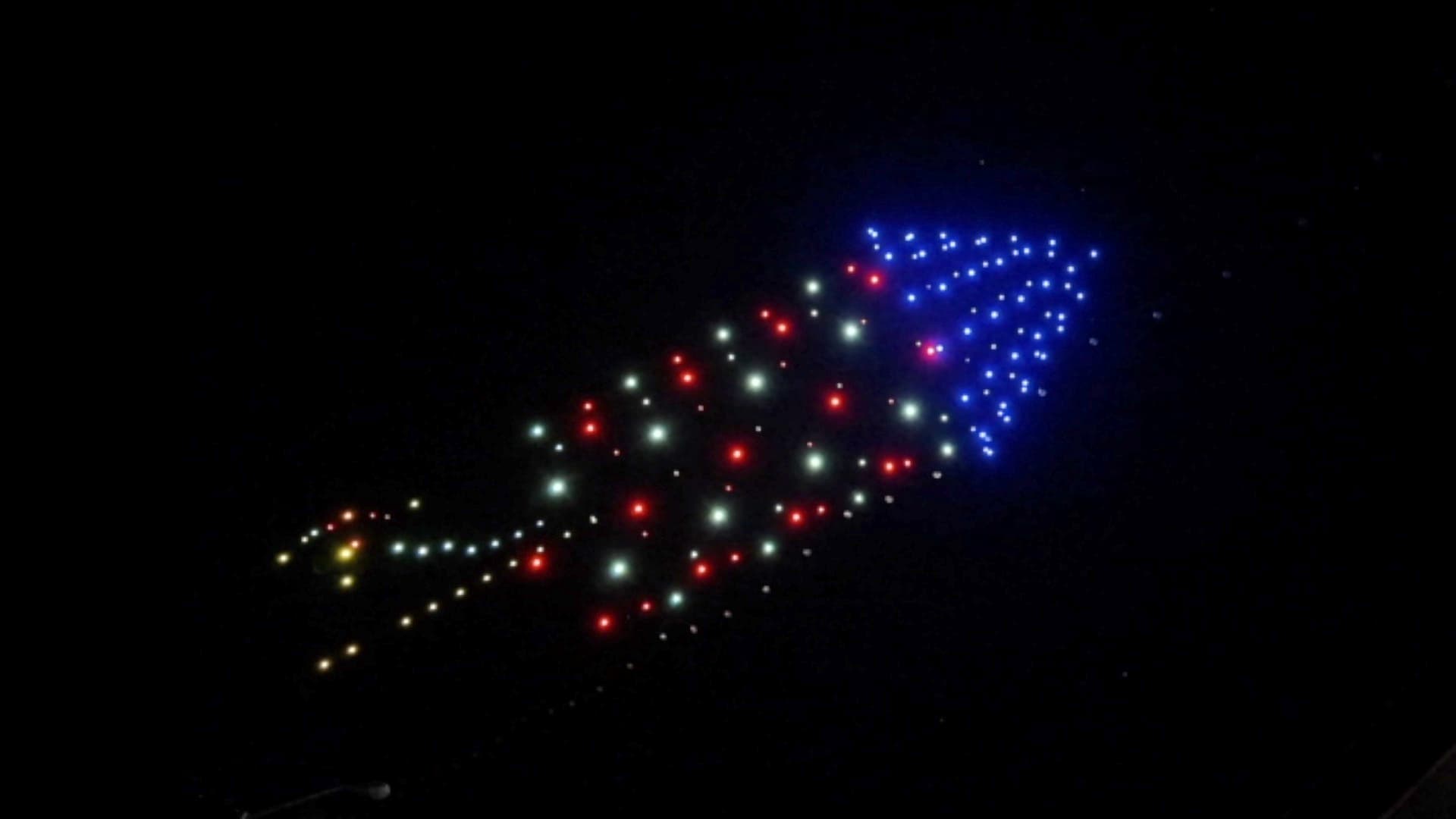 Drones form a rocket with red, white and blue lights