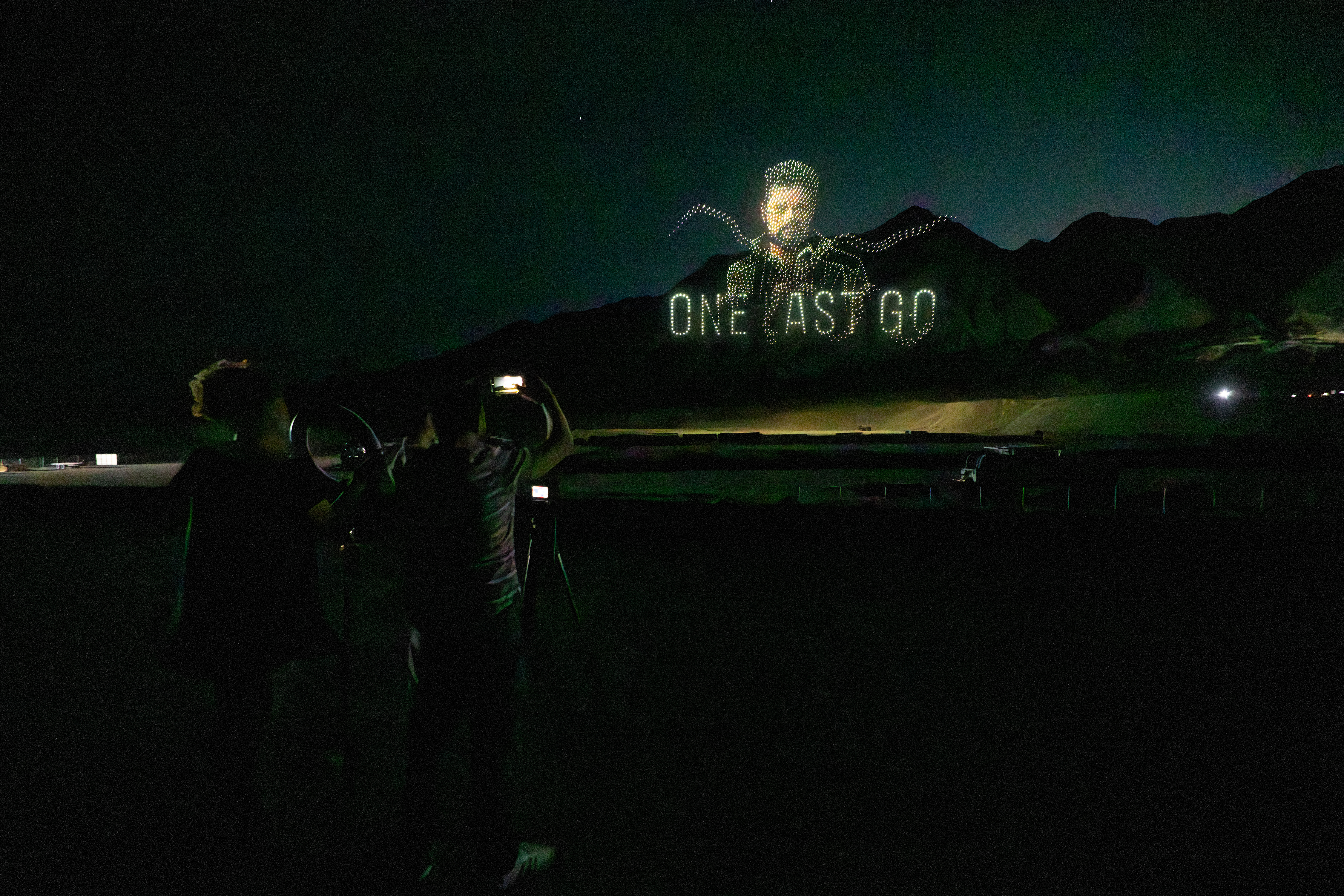 Audience filming a drone formation of Billy Butcher with the phrase One Last Go
